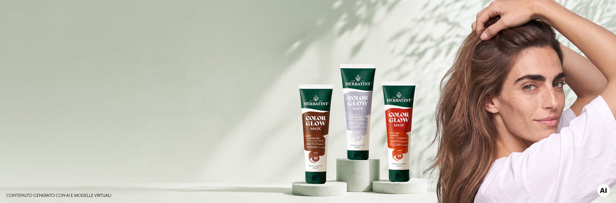 Donna con lunghi capelli castani accanto a tre confezioni di Herbatint Color Glow Mask nelle tonalità Hot Chocolate, Pure Pearl e Intense Copper.