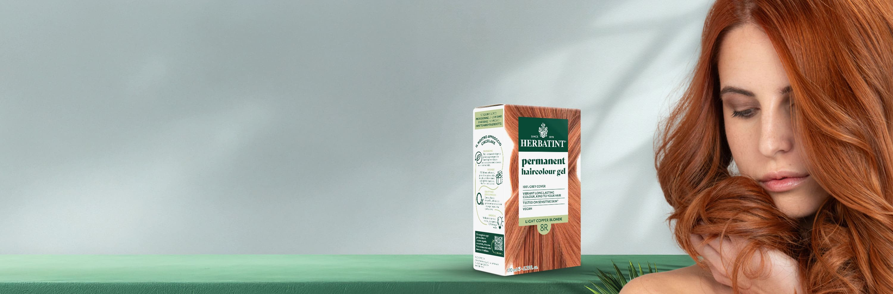 Herbatint 8R light copper-blonde permanent coloring gel box beside a woman with long, glossy copper-blonde hair