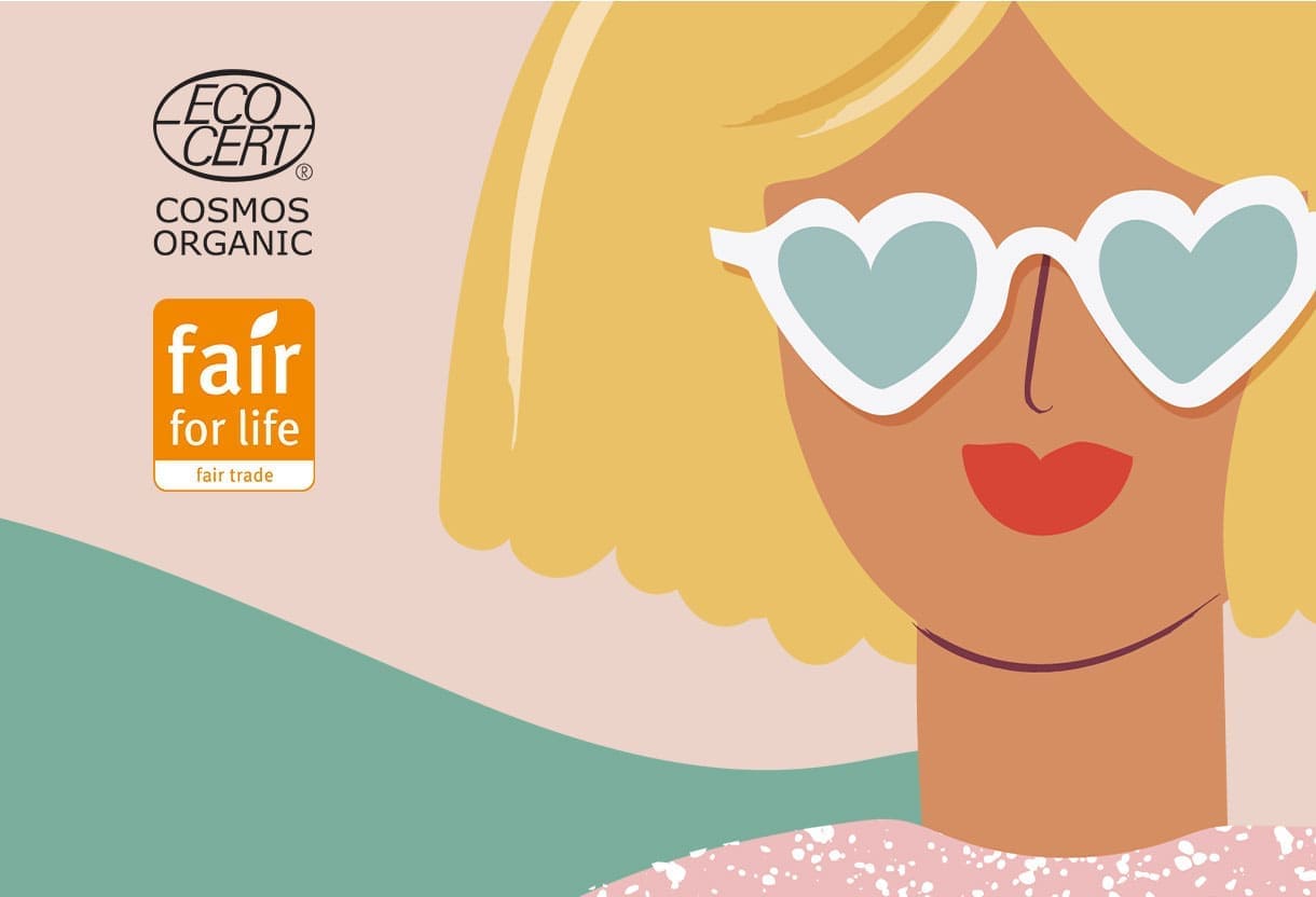 Logótipos de certificação Cosmos Organic e Fair for Life ao lado de uma mulher loira ilustrada com óculos em forma de coração para Herbatint Vegetal Color