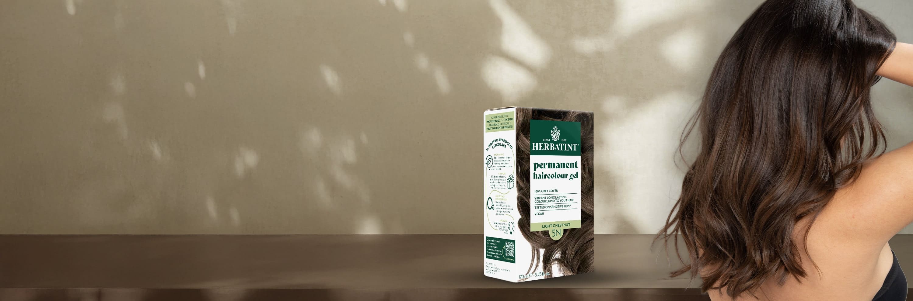 Herbatint permanent coloring gel light brown 5N box beside a woman with healthy, glossy hair in a natural light-brown shade